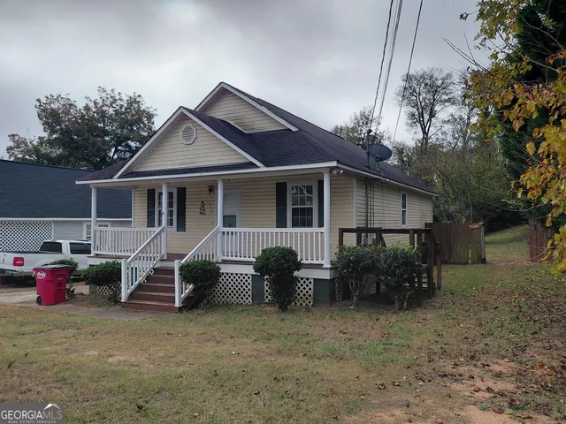 a view of a house with a patio and a yard