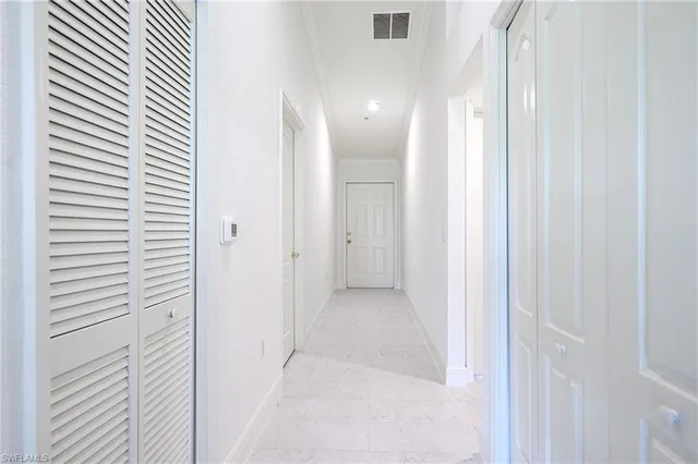 a view of a hallway with closet and bathroom