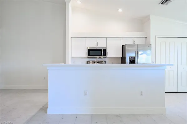 a kitchen with stainless steel appliances a refrigerator and a stove top oven