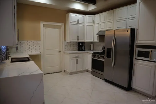 a kitchen with stainless steel appliances granite countertop a refrigerator stove and cabinets