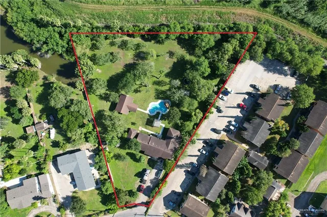 an aerial view of residential house with outdoor space and trees all around