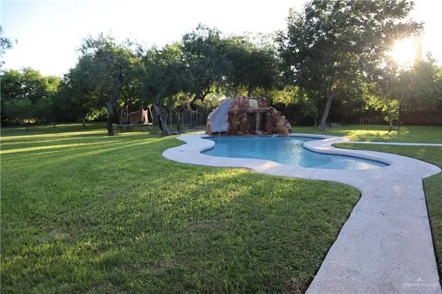 a view of a wooden house with a yard and sitting area