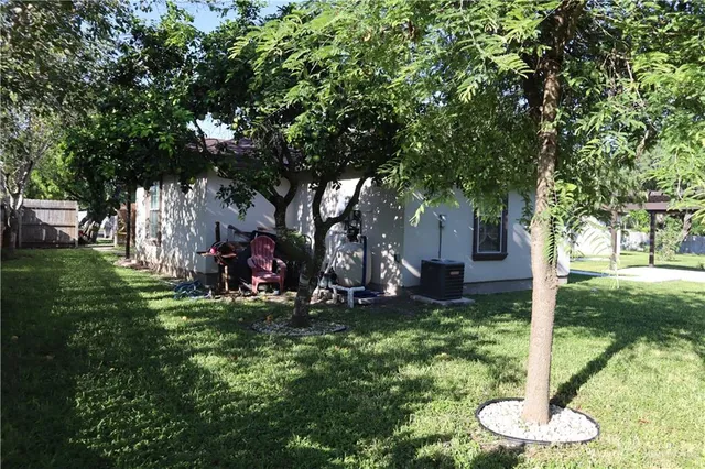 a view of a backyard with table and chairs and a large tree