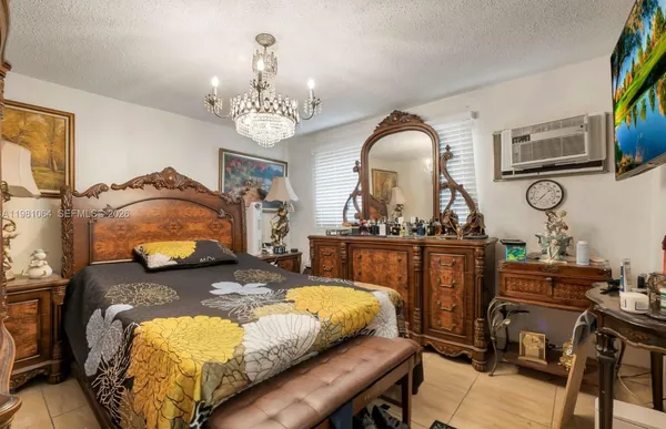 a bedroom with bed and a chandelier