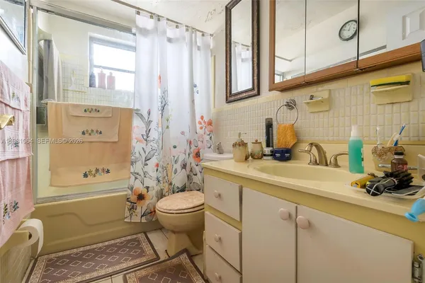 a bathroom with a granite countertop sink a toilet and shower