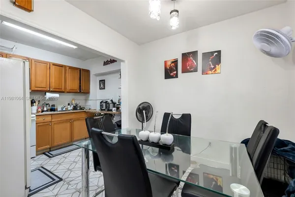 a kitchen with stainless steel appliances granite countertop a stove top oven a dining table and chairs with wooden floor