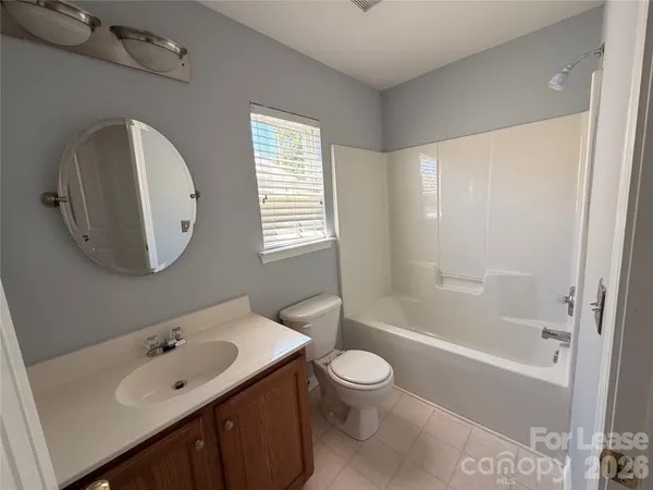 a bathroom with a bathtub shower sink mirror and toilet