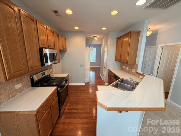 a kitchen with stainless steel appliances granite countertop a sink a stove and a refrigerator