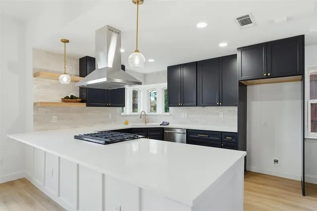 a view of a kitchen with a sink wooden cabinets and a window