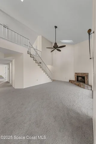 a view of an empty room with a fireplace and a window