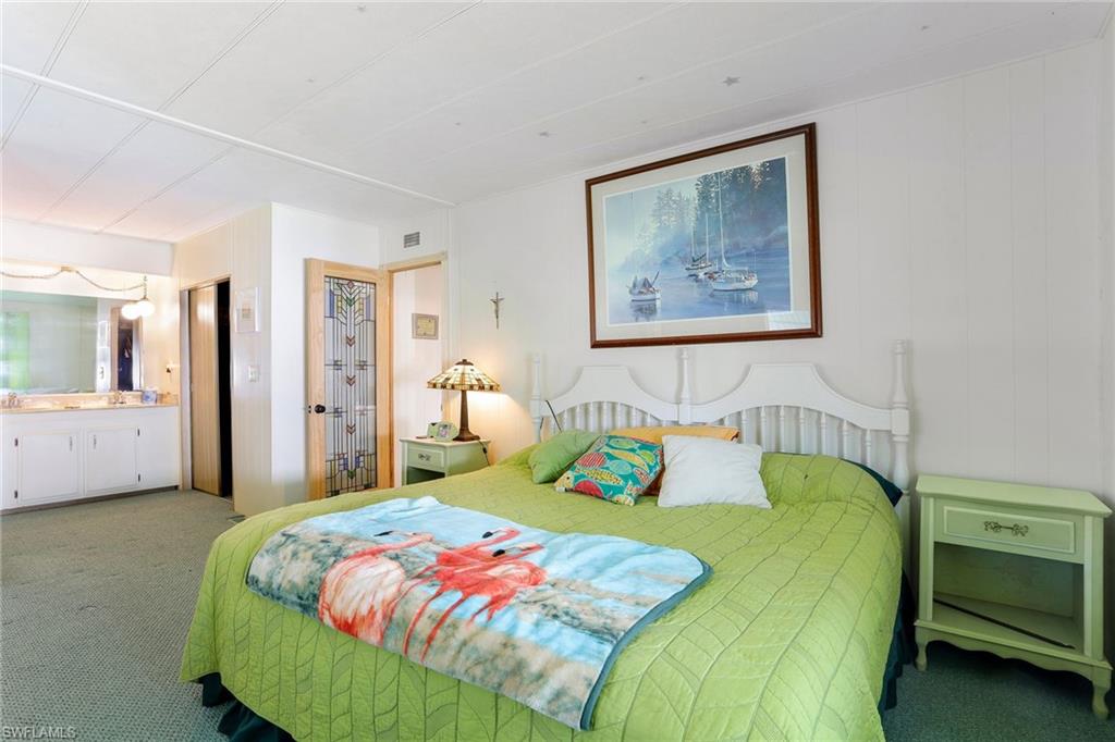 105 Audubon Road Naples, FL 34114 - Photo 15 of 30 a bedroom with a bed and a painting on the wall