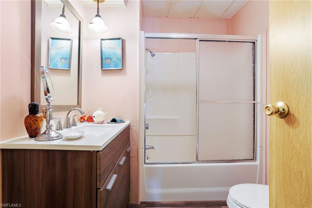 105 Audubon Road Naples, FL 34114 - Photo 19 of 30 a bathroom with a sink vanity mirror and toilet