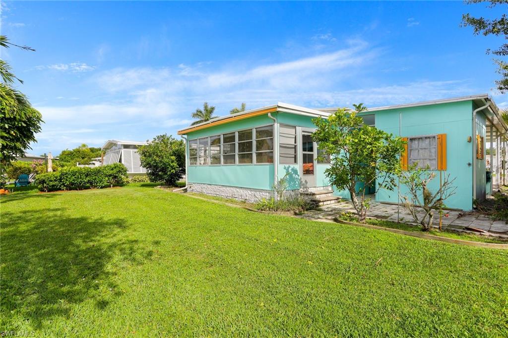 105 Audubon Road Naples, FL 34114 - Photo 24 of 30 a front view of a house with a yard