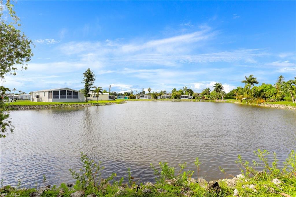 105 Audubon Road Naples, FL 34114 - Photo 25 of 30 a view of a lake with houses in the back