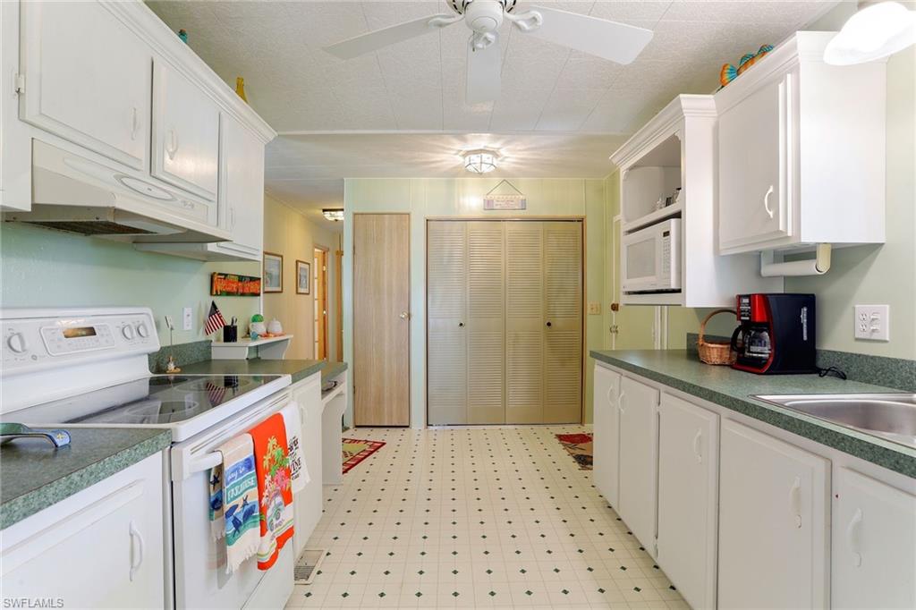 105 Audubon Road Naples, FL 34114 - Photo 3 of 30 a kitchen with stainless steel appliances granite countertop a sink stove and refrigerator