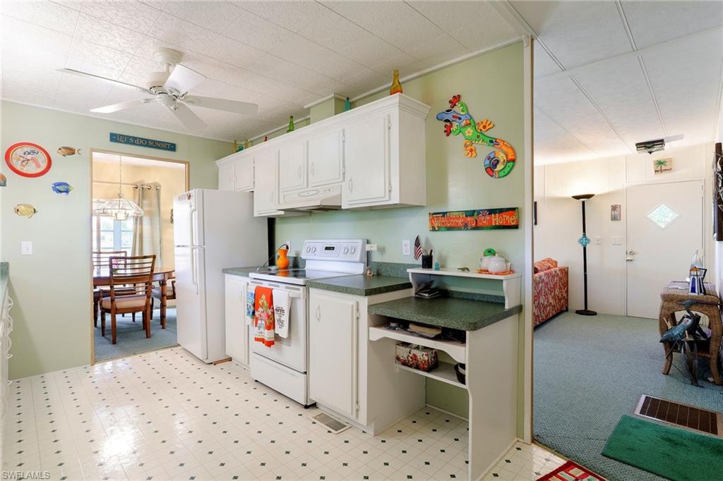 105 Audubon Road Naples, FL 34114 - Photo 6 of 30 a kitchen that has a lot of cabinets a sink and a stove in it