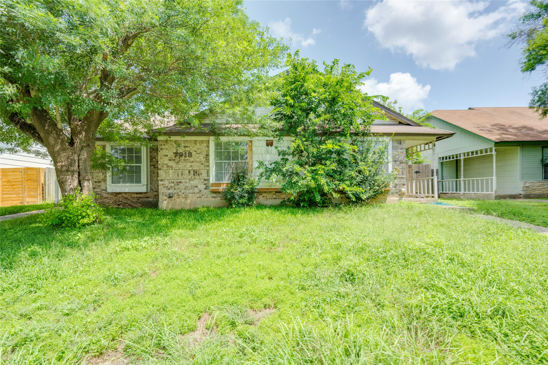 7918 West Gate Boulevard Austin, TX 78745 - Photo 26 of 31 Mature trees frame a charming home with a brick and shingle facade.