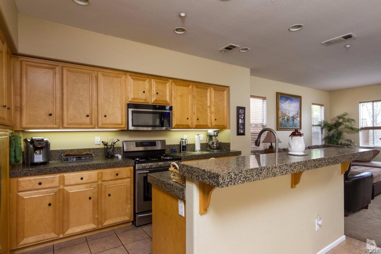 1731 Sonata Drive Oxnard, CA 93030 - Photo 5 of 15 a kitchen with stainless steel appliances granite countertop a stove a sink dishwasher and a microwave oven with white cabinets