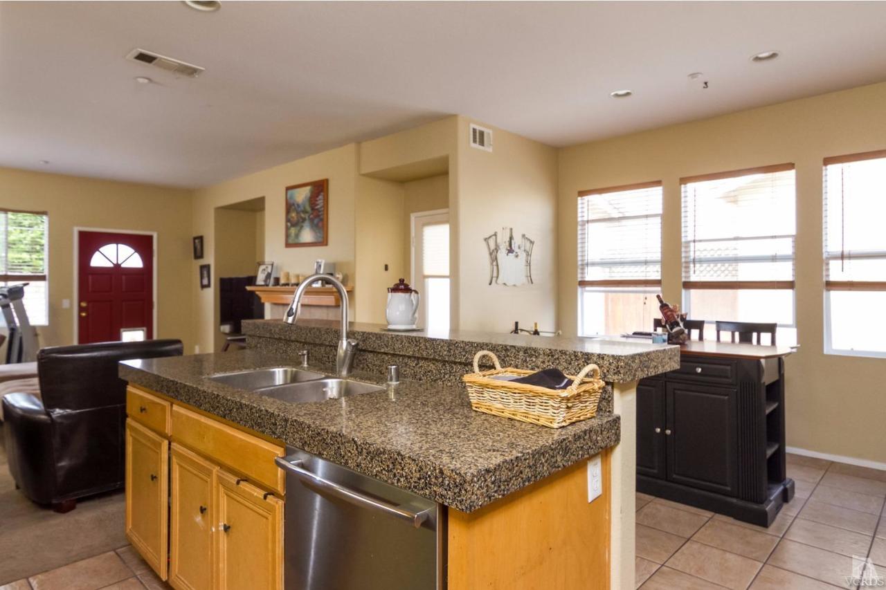 1731 Sonata Drive Oxnard, CA 93030 - Photo 6 of 15 a kitchen with granite countertop sink stove and cabinets