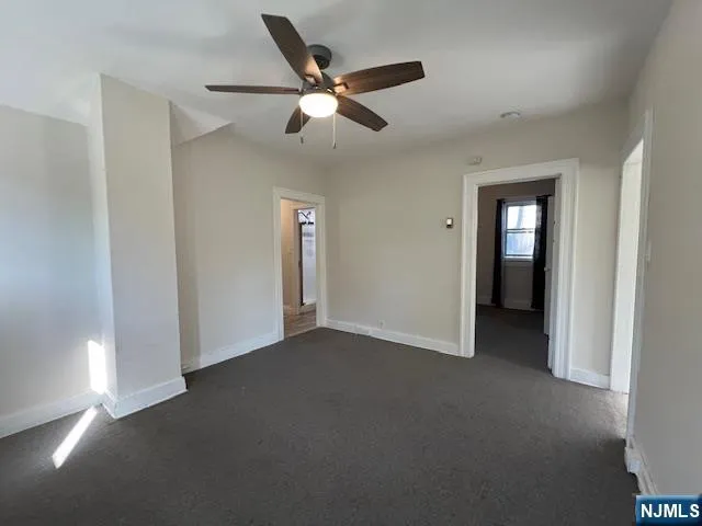 a view of an empty room with a ceiling fan