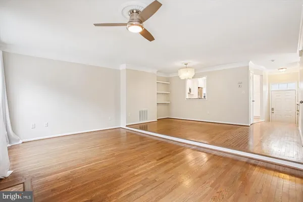 a view of a livingroom with wooden floor and a kitchen