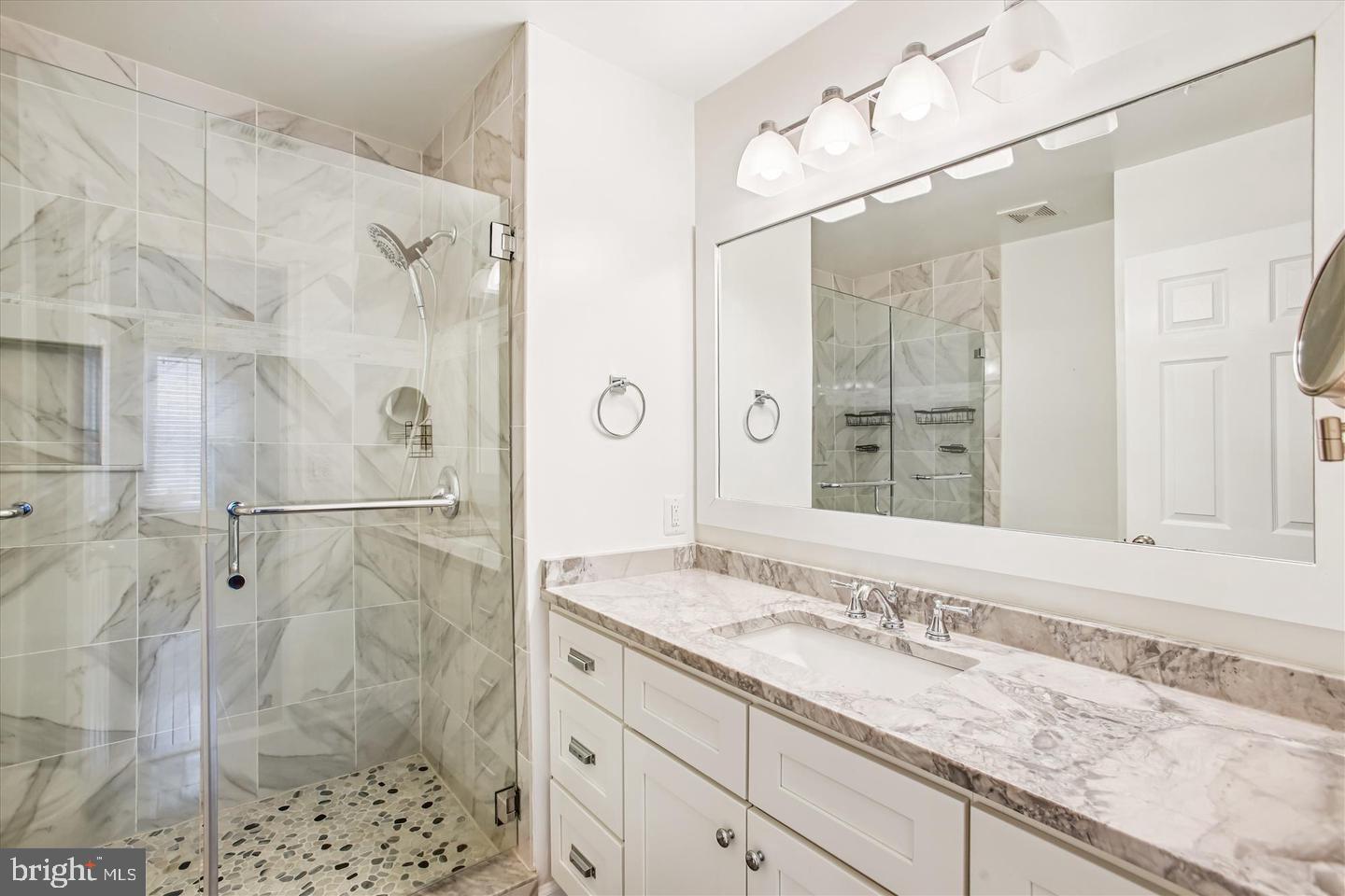 7728 Hickory Glen Way Springfield, VA 22153 - Photo 19 of 35 a bathroom with a granite countertop sink mirror and shower