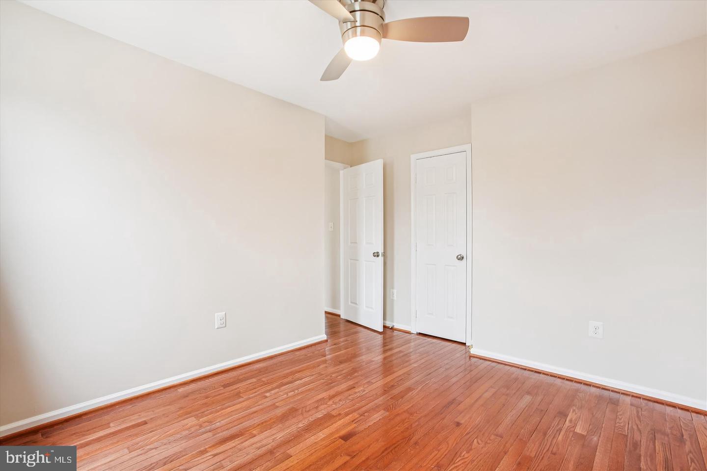 7728 Hickory Glen Way Springfield, VA 22153 - Photo 22 of 35 an empty room with wooden floor and fan