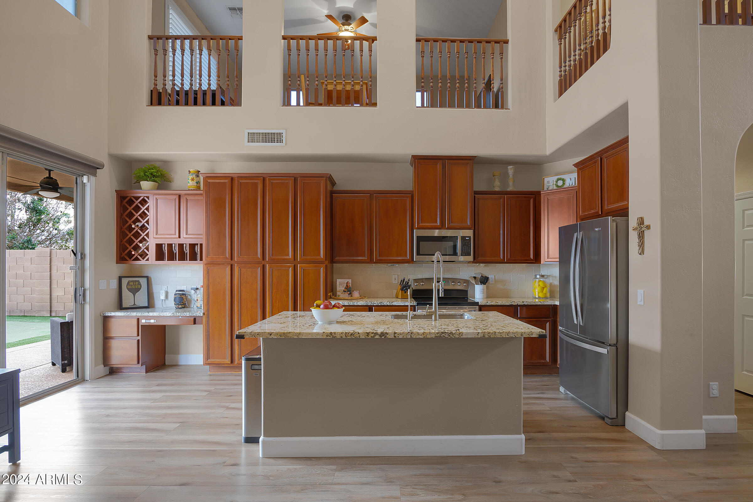 2909 West Silver Fox Way Phoenix, AZ 85045 - Photo 9 of 34 a view of a kitchen with stainless steel appliances wooden floor and a refrigerator