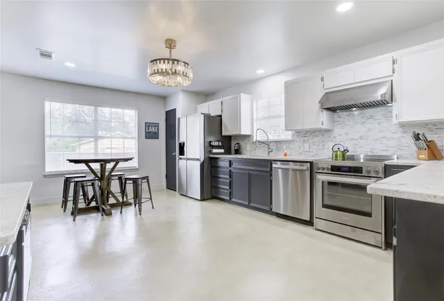 a kitchen with a table chairs stove and cabinets
