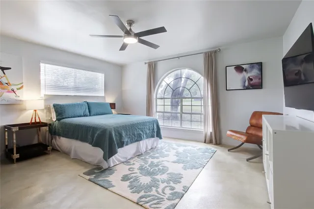 a spacious bedroom with a bed and a large window