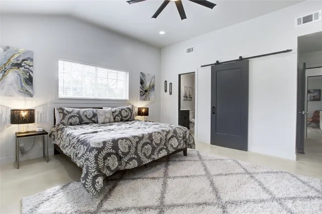 a bedroom with a large bed and a chandelier