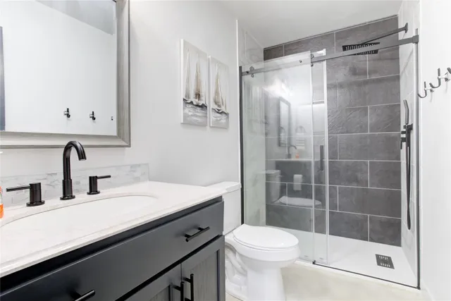 a bathroom with a sink a toilet and shower