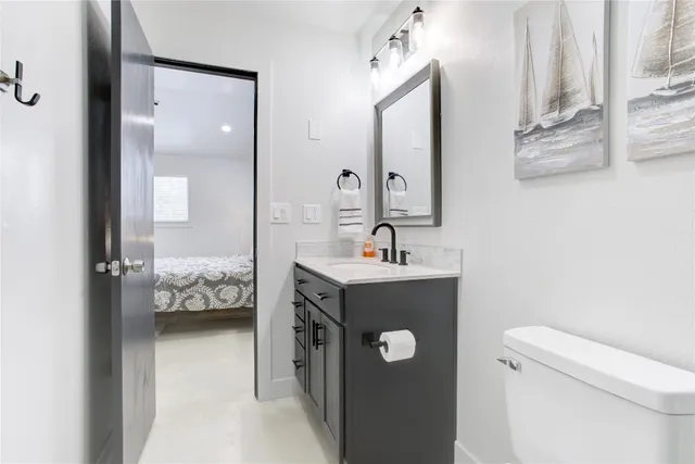 a bathroom with a sink vanity mirror and toilet