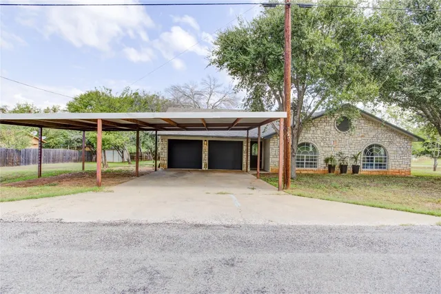 a view of a house with a yard and large tree