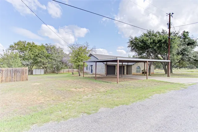 a front view of a house with a garden and trees