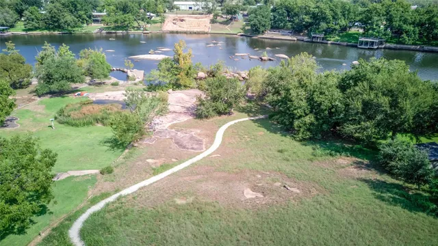an aerial view of a house with a yard and lake