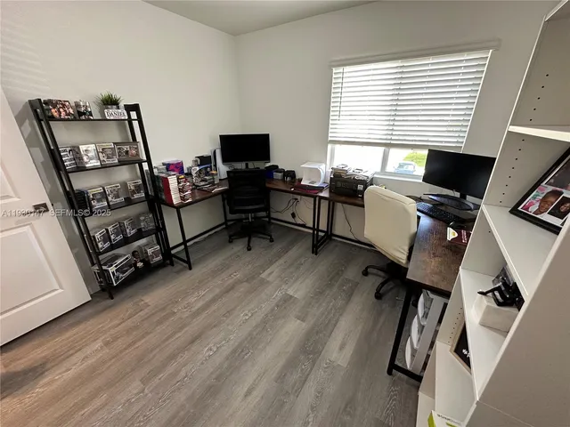 a view of a workspace with furniture and a window