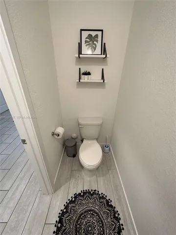 a bathroom with a toilet and a mirror