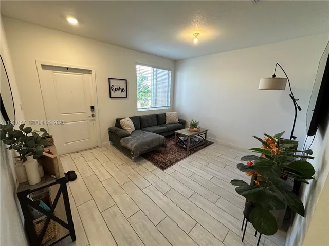 a living room with furniture and a potted plant
