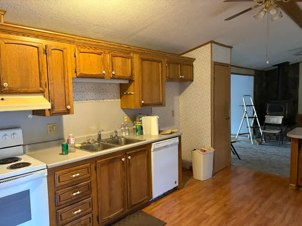 a kitchen with granite countertop a sink cabinets and stainless steel appliances