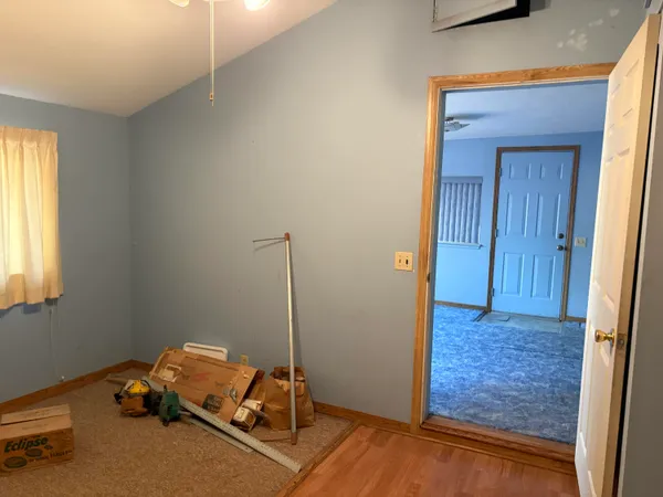 a view of a hallway with a chandelier fan and closet area