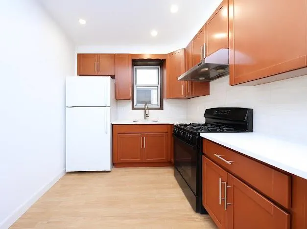 a kitchen with stainless steel appliances granite countertop a sink a stove top oven a counter space and cabinets