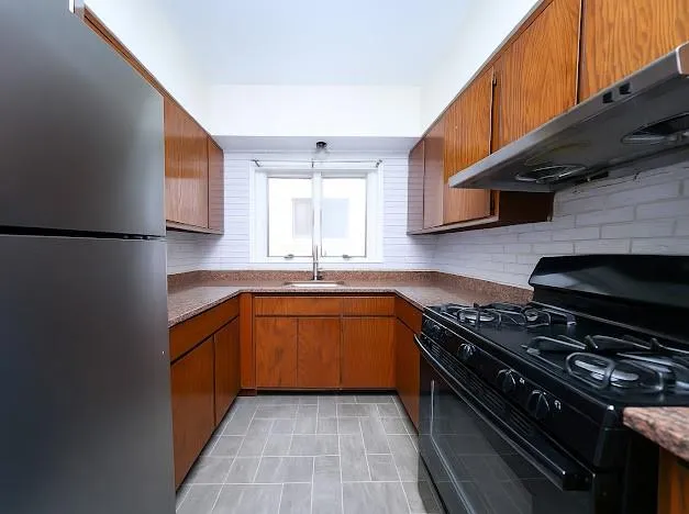 a view of a kitchen with a sink and a refrigerator