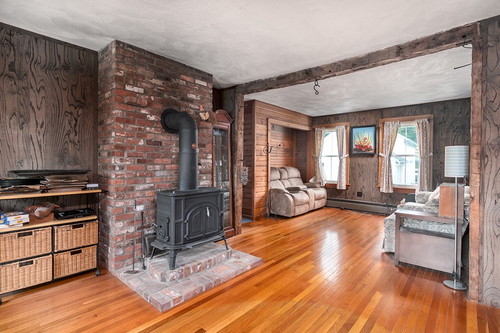 385 Ten Rod Road North Kingstown, RI 02852 - Photo 11 of 36 1st floor living room area with wood stove and hardwood floors