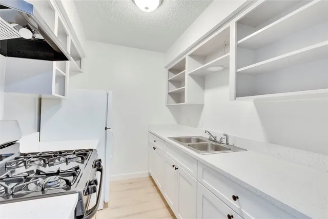 a kitchen with a sink and a stove top oven