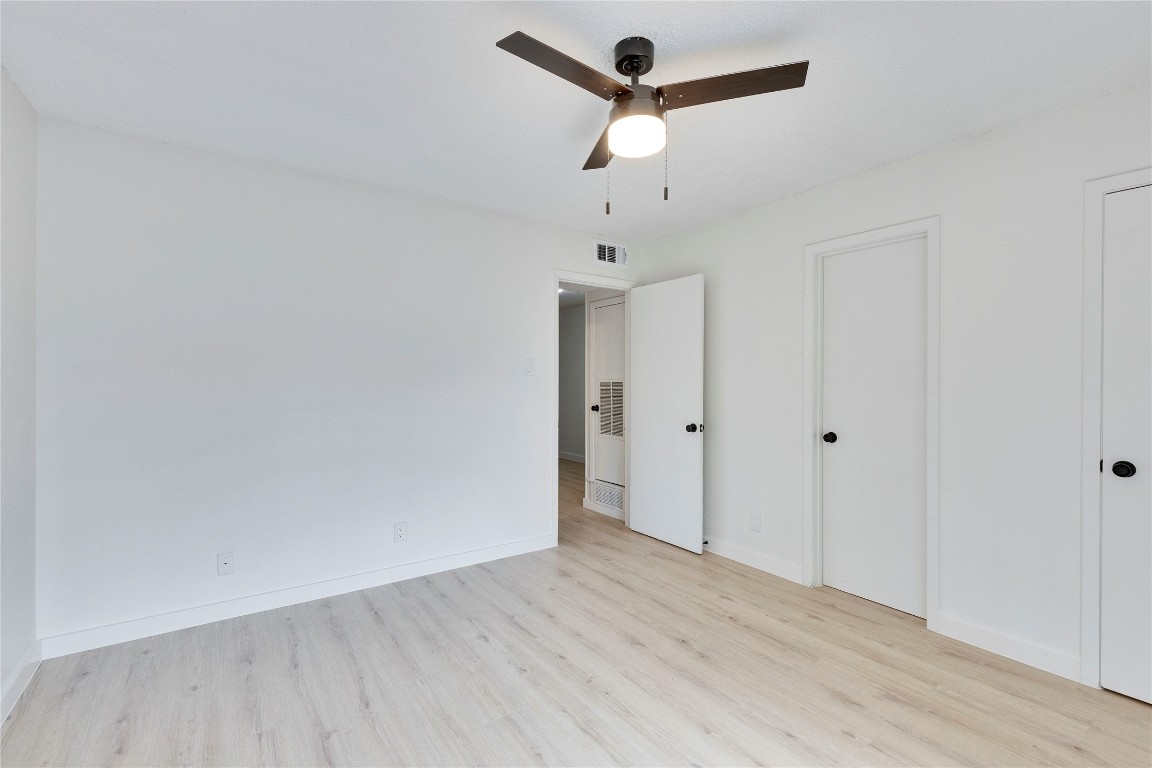 2314 Greenfield Parkway, Unit 108 Austin, TX 78741 - Photo 6 of 23 an empty room with wooden floor and ceiling fan