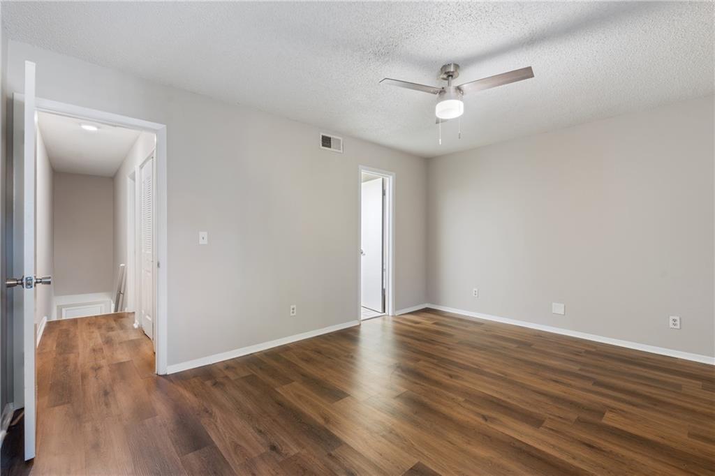 469 Granite Ridge Place Atlanta, GA 30350 - Photo 16 of 18 an empty room with wooden floor and a ceiling fan