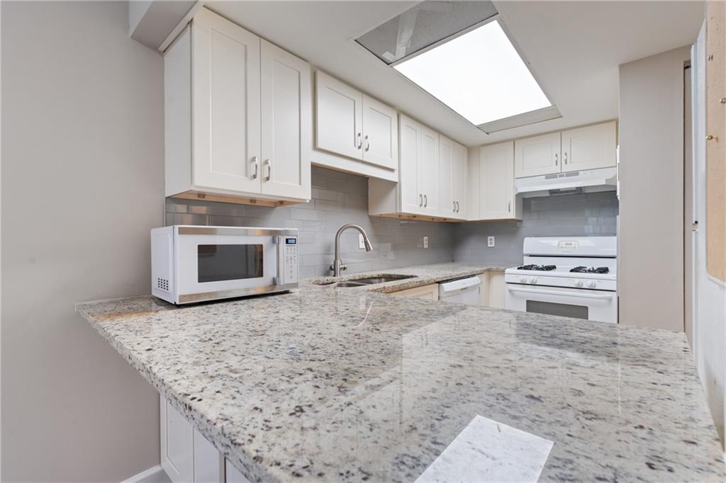 469 Granite Ridge Place Atlanta, GA 30350 - Photo 4 of 18 a kitchen with stainless steel appliances granite countertop a stove a sink and a microwave