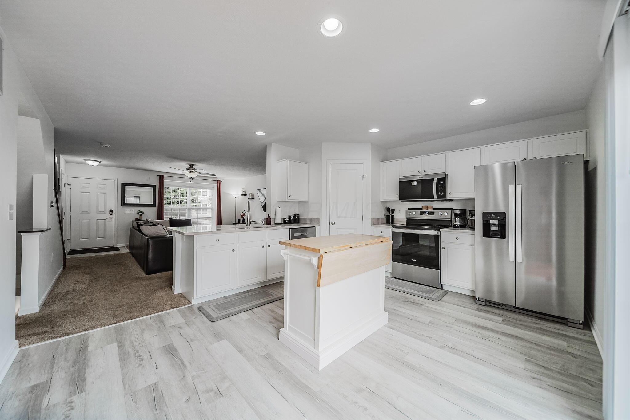 6186 Needletail Road, Unit 66 Columbus, OH 43230 - Photo 7 of 48 Beautiful white cabinetry with brand new (2026) honed granite counters, LVP flooring, and rececced lighting. Large sliding door leads to backyard and garage and floods the area with natrual light!