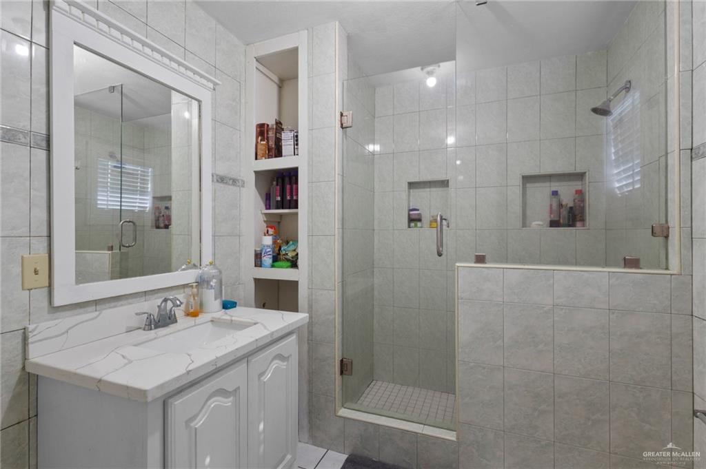 157 San Agustin Street Rio Grande City, TX 78582 - Photo 7 of 17 a bathroom with a granite countertop sink a mirror and a shower